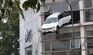 Empleado de concesionaria intentó acomodar un auto y terminó colgando por una ventana