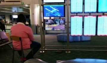 Tranqui, man: aburrido de esperar, conectó la Play Station a una pantalla del aeropuerto y se puso a jugar