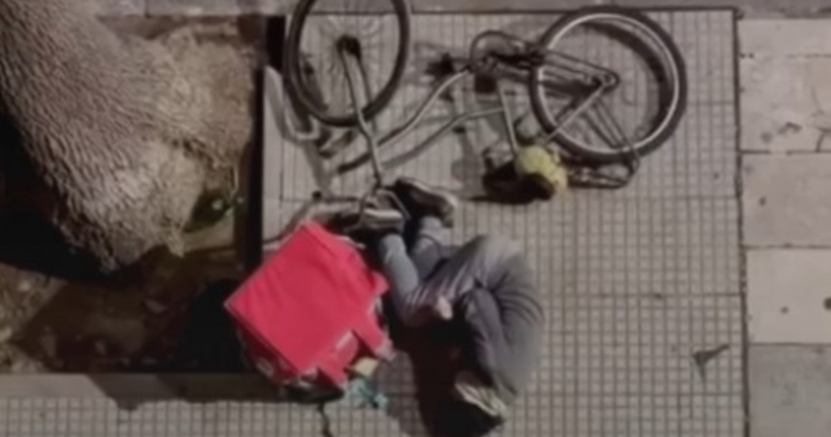 El fotoperiodista Augusto Starita registró a un trabajador de delivery tendido en el suelo y acompañó la imagen con una sola palabra: “laburantes”.